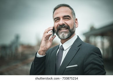 Smart Senior Business Man, An Elderly Entrepreneur And Business Owner, Talking Over His Cell Phone In An Outdoors Urban Area