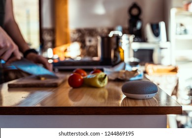 Smart Speaker With Man Cutting Vegetables In The Background