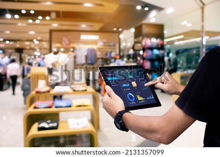 Smart store management systems concept.Manager using digital tablet on blurred store as background