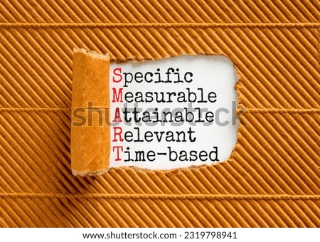 SMART symbol. Concept words SMART specific measurable attainable relevant time-based on paper. Beautiful brown background. Business SMART specific measurable attainable relevant time-based concept.