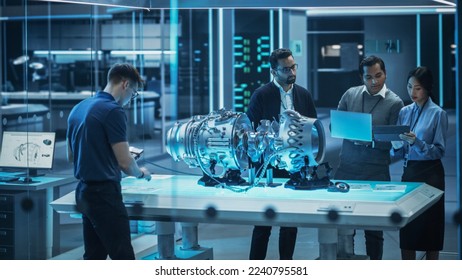 Smart Team of Engineers, Project Manager and Machinery Operators Collaborate on a New Type of a Electric Turbine Engine, Standing with Tablet and Laptop Computers in Scientific Technology Lab.