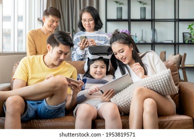 smart technology with lifestyle at home,asian generation family enjoy technology device hand use smartphone tablet and vr goggle glasses play fun together on sofa living room at home quarantine moment - Powered by Shutterstock