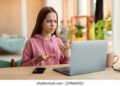 Smart Teen Girl Video Calling On Pc Laptop, Talking And Gesturing At Computer Webcamera. Serious Female Student Looking At Pc Screen Having Video Chat With Teacher