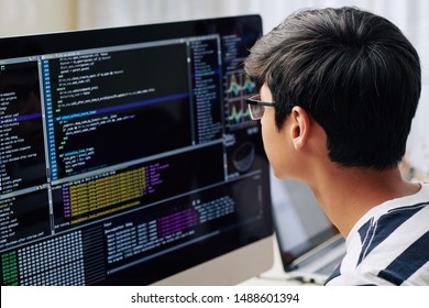 Smart Teenage Boy In Glasses Checking Programming Code On Computer Screen When Sitting At His Desk