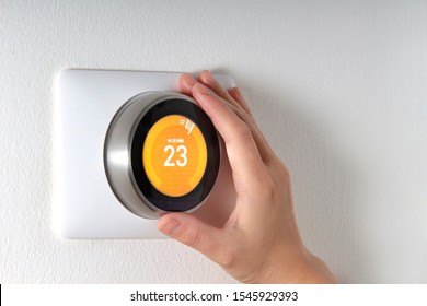 Smart Thermostat With A Hand Setting Up The Temperature