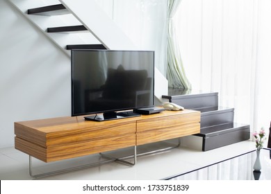 Smart TV wide screen stand on cabinet wooden in the modern living room. Concept of less is more interior design