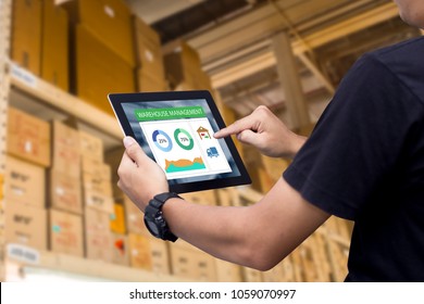 Système de gestion d'entrepôt intelligent.Main d'oeuvre tenant une tablette sur un entrepôt flou en arrière-plan