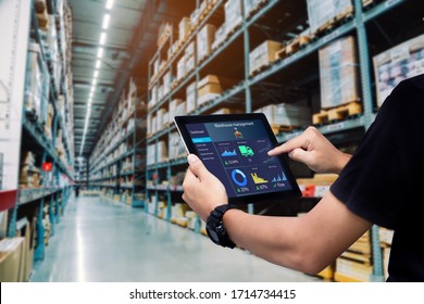 Smart warehouse management system.Worker hands holding tablet on blurred warehouse as background - Shutterstock ID 1714734415