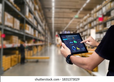Smart warehouse management system.Worker hands holding tablet on blurred warehouse as background