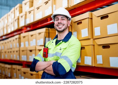 Smart warehouse worker stand and lean against the product boxes on shelves and also look at camea with smiling in workplace.
