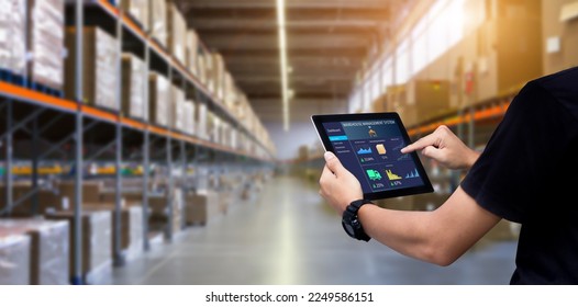 Smart Warehouse,Inventory management system concept.Manager using digital tablet,showing warehouse software management dashboard on blurred warehouse as background - Shutterstock ID 2249586151