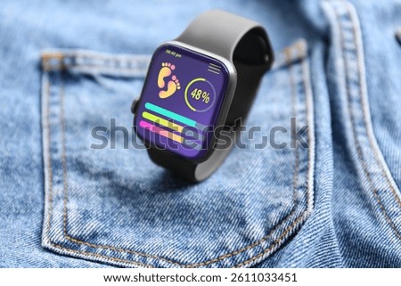 Smart watch with step counting app on jeans, closeup