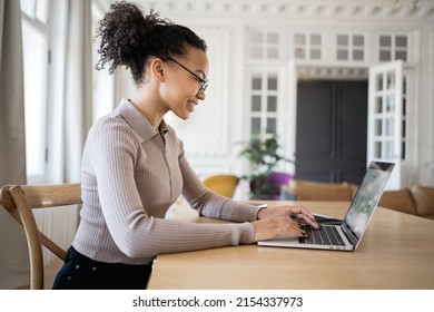 A smart woman with glasses works in a new office, reports online the company's income, uses a laptop. - Shutterstock ID 2154337973