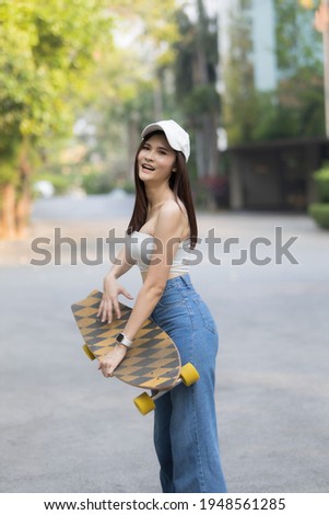 A smart woman play sket board on ground , she is happy and enjoy and fun activity on trend