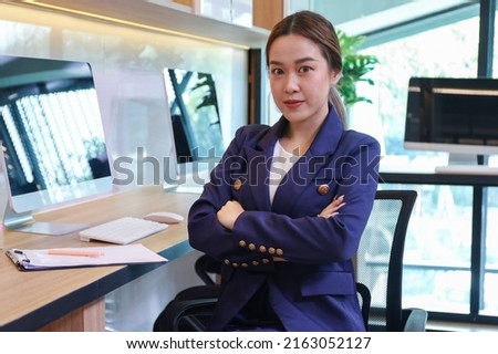 Smart young Asian businesswoman confident posing while using computer and working in office 