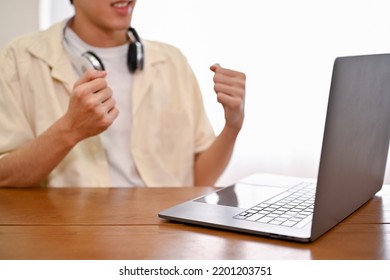 Smart Young Asian Male Office Worker Or College Student Looking At Laptop Screen, Excited About His Exam Results, Job Offer Email, Or Project Success. Cropped Shot