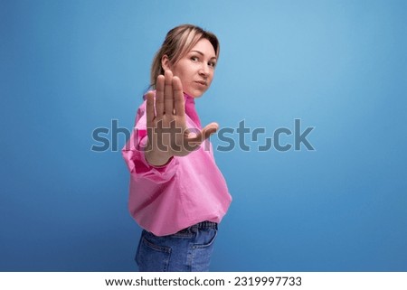 smart young blond businesswoman in a pink shirt and jeans is confident in her business on a studio background with copy space