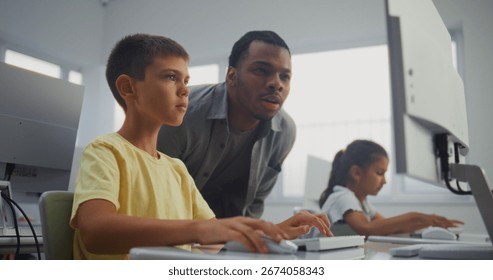 Smart Young Boy Using Computer, Doing Creative 3D Design Project. African American Teacher Helping Elementary School Student in Learning Coding During Digital Programming Lesson. Modern STEM Education