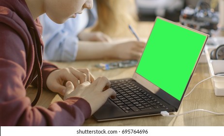 Smart Young Boy Works on a Laptop with Mock-up Green Screen in His Computer Science Class.