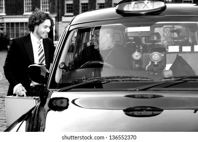 Smart Young Businessman Talking To African Taxi Cab Driver.