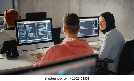 Smart Young Students Studying In University With Diverse Multiethnic Classmates. Scholars Collaborate In College Room On Computer Science Project, Writing Software Code In Successful Teamwork.