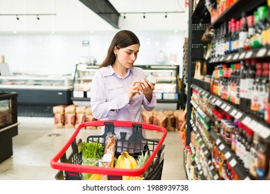 Smart Young Woman Reading The Product Labeling And Checking The Nutritional Information Of A Food Product At The Supermarket