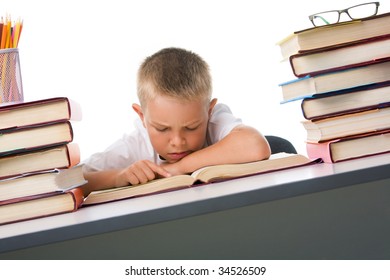 Smart youth reading open book before him with serious facial expression
