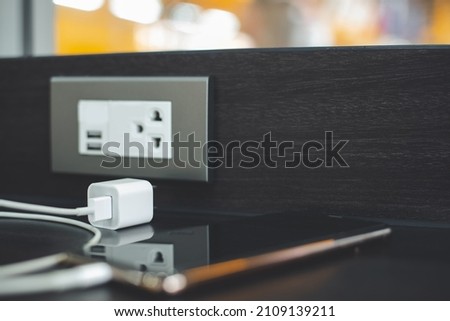 Smartphone and adapter placed on desk unplug after charging the battery.