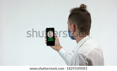 The smartphone app checking face mask. Man in protective face mask unlocks phone screen using face id. Isolated on white background.