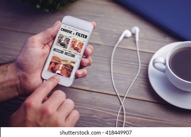 Smartphone app menu against person holding smart phone at desk