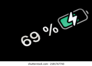 Smartphone Battery Level Indicator Charging Process - White Pixel Number - Sixty Nine, 69 Percent: Close Up Macro View Of Gadget Display, Screen, Black Background. Energy, Power, Digital Concept