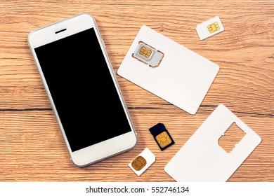 Smartphone with blank screen and SIM cards on the table, top view