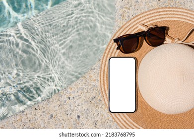 Smartphone With A Blank White Display On A Straw Hat By The Pool In The Hotel. Top View, Mock Up.