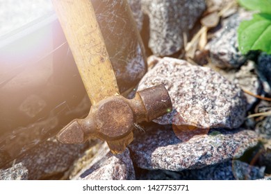 Smartphone Broken Glass With Hammer On Gravel Stones. Selective Focus With Sum Beam.