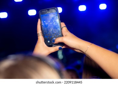 Smartphone Capture Image Concert, Festival, Crowded Place Phone Above Head Taking Photos. Hands Holding Phone In Ambient Music Environment