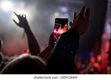 Smartphone Capture Image Concert, Festival, Crowded Place Phone Above Head Taking Photos. Hands Holding Phone In Ambient Music Environment