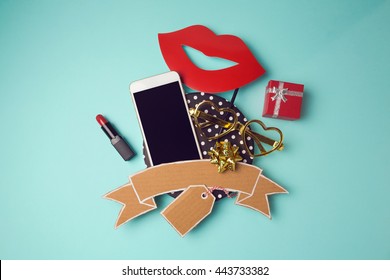 Smartphone With Cardboard Banner, Lipstick And Gift Box. Creative Website Hero Image. View From Above