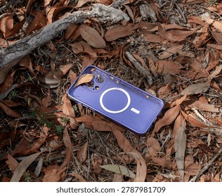 A smartphone case in pristine condition has been dropped on the ground among dry leaves
