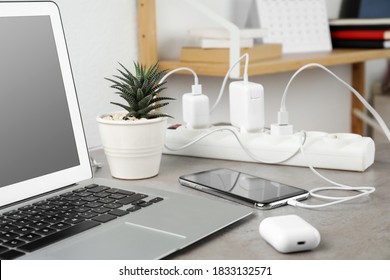 Smartphone charging with cable on light stone table