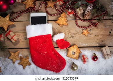 Smartphone in a Christmas sock on wood - Powered by Shutterstock