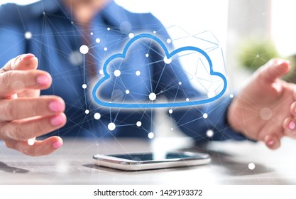 Smartphone with cloud networking concept between hands of a woman in background