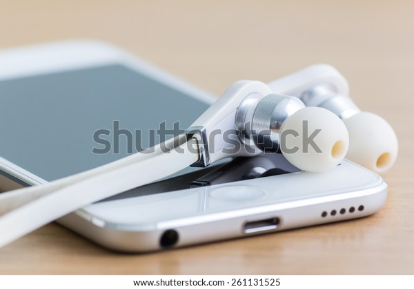 Smartphone Earphones On Table Focus On Stock Photo (Edit Now) 261131525