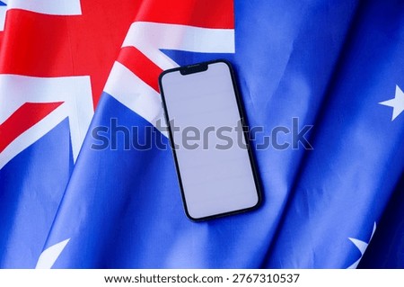 Smartphone with empty white screen on background of Australian flag. Mock up template copy space for custom copy designs. Place your logo or text on the white screen phone