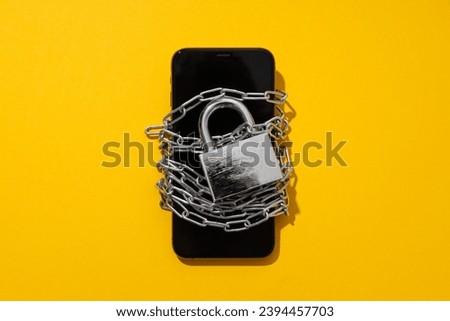 The smartphone is encased in a chain with a lock