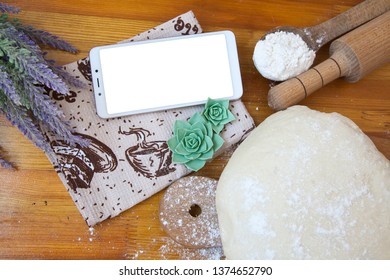 smartphone (for text) on the table near the dough and flour