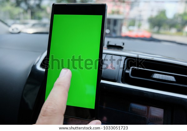 a smartphone with green blank screen in\
the car for direction, massage,\
location