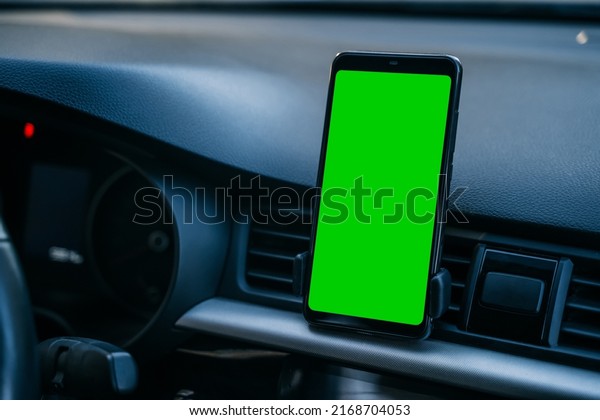 Smartphone with a green screen in the car.\
Navigation in a smartphone.\
Mockup