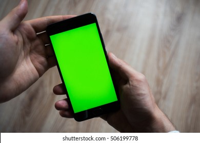 smartphone with green screen for key chroma screen. In the hands - Powered by Shutterstock