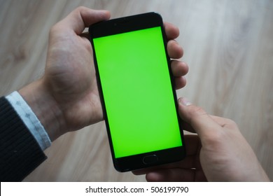 Smartphone With Green Screen For Key Chroma Screen. In The Hands