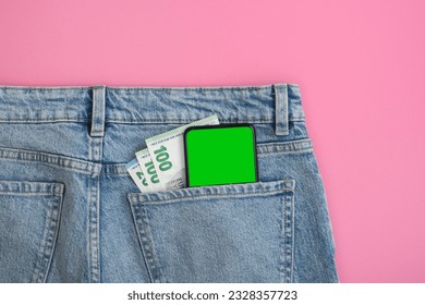 Smartphone green screen mockup and euro bills in back pocket of blue jeans on pink background. Banner with no people. - Powered by Shutterstock